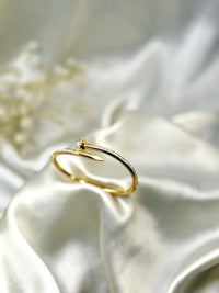 Elegant gold bracelet with diamond accents on white satin fabric