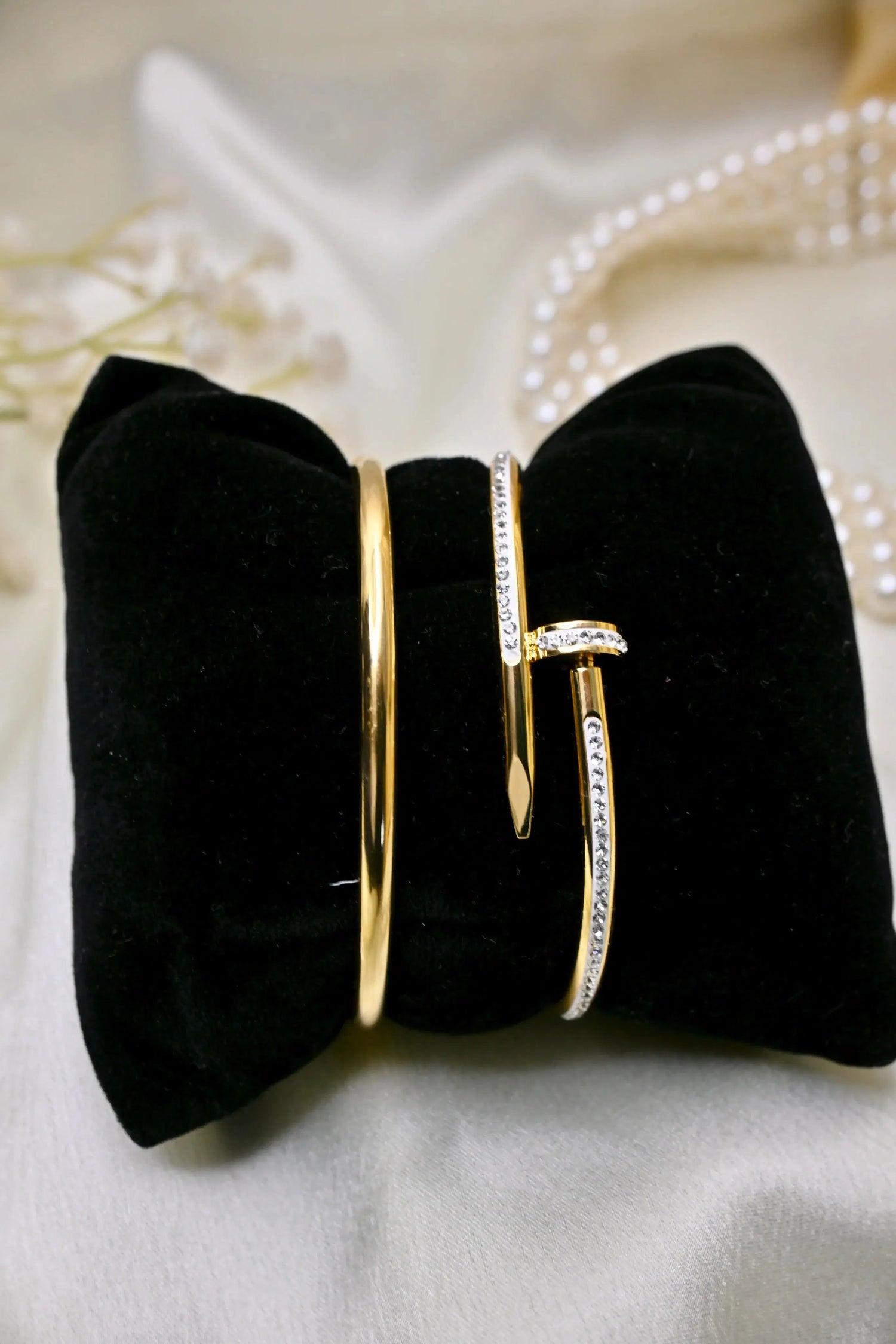Gold bangles with diamond accents displayed on black velvet, elegant jewelry close-up