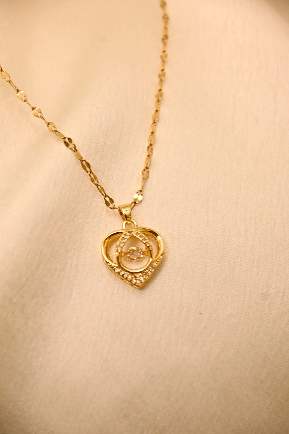 Gold heart-shaped pendant necklace with diamond accents on a delicate chain