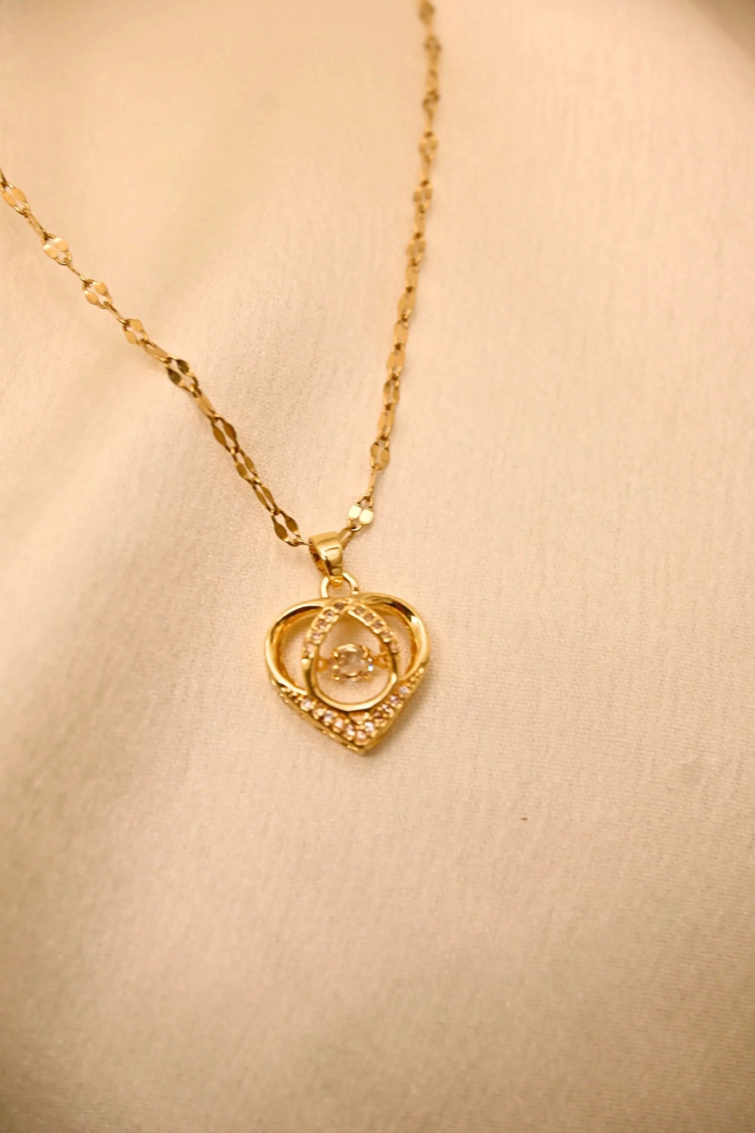 Gold heart-shaped pendant necklace with diamond accents on a delicate chain
